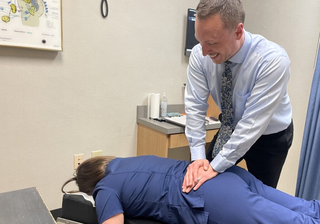 Dr. Charlie Gray giving the man a lower back pain treatment